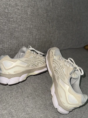 Beige och vita sneakers med meshdetaljer - Asics skor, säljer pga köpte fel storlek, använd 1 gång typ som helt ny.  ❌! DEN ÄR STORLEK 38!!! Pris kan ej diskuteras köp 600 eller inte.