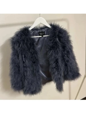 Mörkgrå fluffig fjäderjacka - Supersnygg mörkgrå pälsjacka med fluffig och mjuk känsla.  Fodrad insida i matchande färg ger extra komfort. Perfekt för dig som vill sticka ut med en trendig look. Nypris är några tusenlappar. Aldrig använd. Passar storlek S, XS och XXS. Äkta strutsfjäder