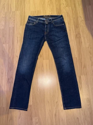 Jacob Cohën 31 - Mörkblå Jacob Cohën 688 Comfort jeans i storlek W31 i nästintill nyskick. Tveka inte på att höra av dig för fler bilder eller vid minsta fundering! Självklart äkta. Skick: 9,5/10 | Mått midja: 42cm | Mått längd: 100cm.