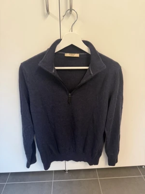 Beymen mörkblå tröja zip, Storlek XL men sitter som XS 100% Ull - Mörkblå stickad tröja med halv dragkedja och hög krage. Tröjan har långa ärmar och ribbade muddar vid ärmslut och nederkant. Perfekt för lager på lager och enkel att matcha med jeans eller chinos. NYPRIS: 3500kr