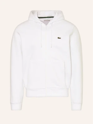 Vit hoodie från Lacoste med dragkedja - Säljer en klassisk vit hoodie från Lacoste i storlek S. Hoodien har dragkedja, huva med snören och två stora fickor framtill. Ikoniska Lacoste-loggan i grönt broderad på bröstet. Perfekt för en clean och stilren look.
