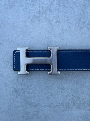 Blått Herme’s bälte - Blått Herme’s med silverfärgat spänne. Stilrent bälte som passar både till vardag och finare outfits.