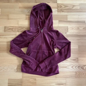 Vinröd Juicy Couture tröja  - Vinröd Juicy Couture tröja i storlek s. Tröjan är vinröd men i ljuset ser den lila ut.