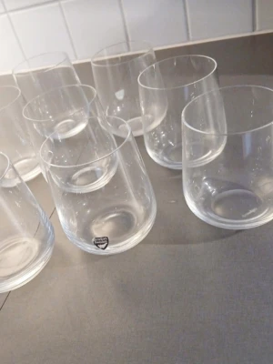 Åtta runda dricksglas i glas - Säljer åtta stilrena, genomskinliga dricksglas med rund form. Perfekta till vatten, juice eller . Från orrefors 