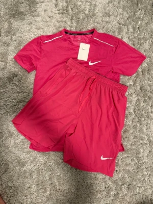  Nike -  Säljer detta grymma Nike träningsset i en härlig röd/rosa färg.  helt nya med taggarna kvar.