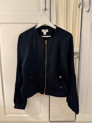 Mörkblå zip up tröja - Mörkblå zip up jacka i sidenliknande material med gulddetaljer över hela! Superfin🤩 Skriv vid frågor, köp gärna direkt💖