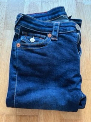 True religion mörkblå becca  - Säljer ett par mörkblå true religion i becca. Väldigt snygga! Jeansen är lite slitna längst ner men de syns inte så mycket och det är inget man tänker på.