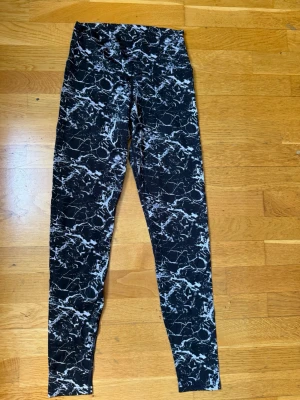 Svarta leggings med marmormönster - Snygga svarta leggings med vitt marmormönster och hög midja. Stretchigt material som sitter skönt och formar sig efter kroppen. Perfekta till träning eller chill. Mönstret ger en cool och unik look. Vet inte storleken men kan mäta midjan!! . Skriv privat för fler bilder eller om du har några frågor💗