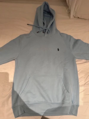 Polo Raulph Lauren hoodie - Snygg ljusblå hoodie med huva och dragsko, samt en klassisk känguruficka framtill. Liten broderad logga på bröstet. Perfekt för en chill och avslappnad stil. Skicket är utmärkt. 