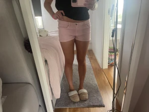 Ljusrosa midwaist shorts i bomull - Säljer ett par ljusrosa shorts med midwaist passform. De har klassisk femficksdesign, knapp och dragkedja framtill samt uppvikta benslut. Perfekta för sommaren och riktigt sköna att bära till vardags.