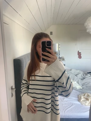 Vit stickad tröja med svarta ränder - Oversized stickad tröja. Perfekt för en avslappnad och trendig look. storlek M men passar mig som bär XS i vanliga fall.