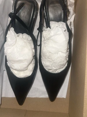 Svarta klackskor  - Svarta klackskor, slingback pumps ifrån bershka. Helt nya och oanvända i storlek 39.