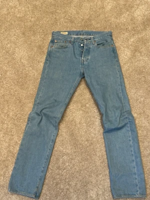 Ljusblåa Levi’s 501 - Säljer ett par klassiska ljusblå Levi’s jeans. Säljs då de är för små för mig och används inte. W29 L32. Jeansen är lite baggy, perfekt för dig som gillar en avslappnad streetstil. Tveka inte på att höra av dig ifall du har nån fundering! 