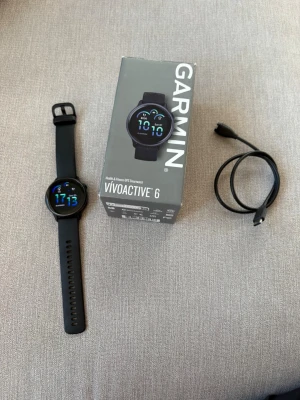 Garmin vívoactive 6 GPS Smartwatch – svart - Garmin vívoactive 6 i perfekt skick, endast använd i ungefär en vecka. Klockan är som ny, utan spår av användning, och fungerar självklart precis som den ska.  Perfekt för träning, löpning, gym och vardag med bland annat GPS, pulsmätning, sömnregistrering, aktivitetsmätning och Garmins olika hälso- och träningsfunktioner. Klockan har även tillgång till Garmin golf  Kommer komplett med originalkartong, laddkabel och dokumentation enligt bilderna.  