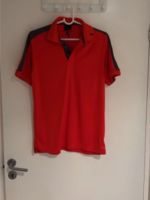 Pike från Peak Performance - Orange golf-pike, med grå detaljer ifrån Peak Performance. Gott skick då den inte använts så mycket. 