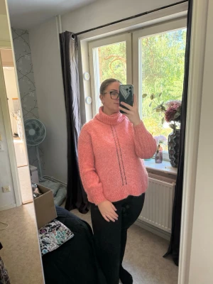 Rosa stickad polotröja med omlott - Mysig rosa stickad tröja med hög polokrage och dekorativt omlott bak. Tröjan har en lös passform, långa ärmar och ett diskret mönster framtill. Perfekt för kyliga dagar och enkel att styla med jeans eller leggings. Från märket Odd Molly i storlek 2 som enligt deras storlekguide motsvarar en storlek M. Jag har vanligtvis en 4/XL. Passar en M/L.  Mycket fint skick, jag hittar inga synliga anmärkningar eller defekter. Ytludd och noppror kan förekomma.  