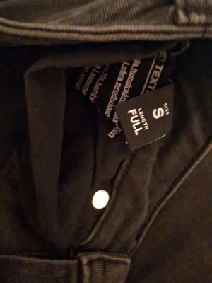Svarta bootcut jeans från 157 - Säljer ett par svarta bootcut jeans från 157 i storlek S. Jeansen har full längd och klassisk femficksdesign med silverfärgade knappar och nitar. Perfekta för dig som gillar 90-talsvibbar och vill ha ett par stilrena jeans i garderoben.