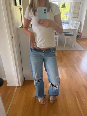 Ljusblå baggy ripped jeans - Säljer ett par ljusblå baggy jeans med slitna hål på knäna och raka ben. Storlek 32, inte så använda