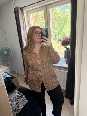 Mönstrad blus med knappar - Säljer en bohemisk blus med orange och blått mönster. Blusen har långa ärmar med resår vid handlederna och knäppning framtill med dekorativa knappar. Materialet känns lätt och luftigt, perfekt för dig som gillar färg och mönster. Från märket Odd Molly i storlek 2 som enligt deras storlekguide motsvarar en storlek M. Jag har vanligtvis en 4/XL. Men denna är något liten på mig. Mer en L/XL. Mycket fint skick, jag hittar inga synliga anmärkningar eller defekter. 