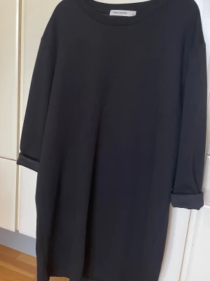 Carin Wester långärmad tröja stl L - En stilren svart långärmad tröja från Carin Wester i storlek L. Tröjan har en enkel och rak passform med rund halsringning och uppvikta ärmslut. Perfekt basplagg till garderoben.