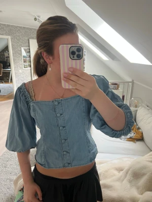 Trendig jeans blus  - Trendig ljusblå blus i denim-look med puffiga trekvartsärmar och knappar framtill. Från hm men köpt på Sellpy, inga defekter men en knapp känns lite lös