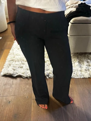 Svarta raka kostymbyxor - Snygga svarta kostymbyxor med rak passform. Byxorna har diskreta fickor och stängs med dragkedja och hake. Perfekta för en clean och stilren look. Knappt använda 
