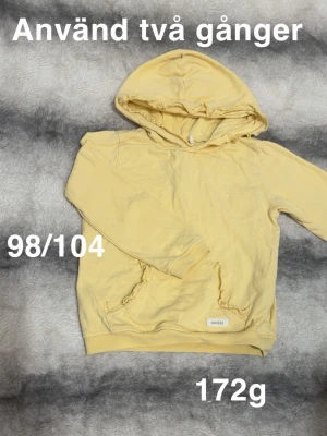 Gul hoodie med huva - Ljusgul hoodie med huva och magficka. Tröjan har ribbade muddar vid ärmslut och nederkant samt en enkel, clean design utan tryck. Perfekt för en avslappnad och bekväm stil.🌸 Använd två gånger. Storlek 98/104