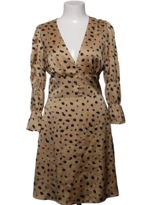 Beige klänning med svarta prickar från adoore  - Snygg beige klänning med svarta prickar och v-ringning. Klänningen har långärmade ärmar med lätt puff och markerad midja. Tillverkad i ett glansigt material som ger en lyxig känsla. Perfekt för dig som vill sticka ut med ett trendigt mönster. Prickig klänning från adoore 