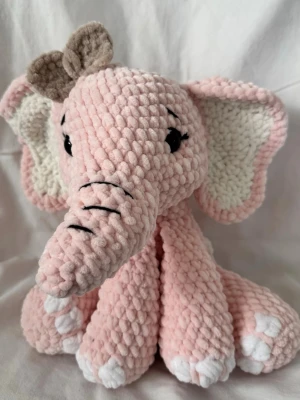 Rosa virkad elefant gosedjur - Supergullig handvirkad elefant i mjukt sammet/polyester garn (DMC Velvet). Elefanten har stora öron, söt snabel och en liten söt rosett. Perfekt som present eller dekoration🐘🩷. Är ungefär 22cm hög.