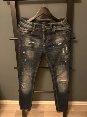 Mörkblå slitna jeans - Snygga mörkblå jeans med slitningar. Jeansen har klassisk femficksdesign, låg midja och smal passform. Perfekta för en trendig och avslappnad look, använt fåtal gånger.  Hör av er vid frågor!😃 