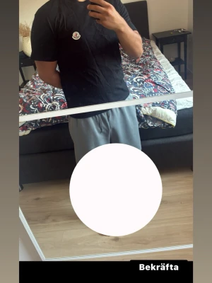 Svart Moncler t-shirt med logga - Säljer en svart t-shirt med rund hals och en liten logga på bröstet. T-shirten har korta ärmar och en klassisk passform som funkar till det mesta. Perfekt basplagg för dig som gillar enkel och stilren stil.