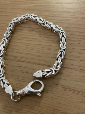 Flätat armband i äkta silver - Snyggt armband i 925 sterling silver med flätad design och kraftig karbinhake. Armbandet har en stilren och tidlös look som passar perfekt till alla outfits. Märkt med 925 för äkthet. Perfekt accessoar för dig som gillar klassiska smycken.
