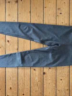 Mörkgråa mjuka träningsbyxor från Uniqlo storlek XS - Säljer ett par mörkgråa träningsbyxor i mjukt och stretchigt material. från Uniqlo i storlek XS. Perfekt skick! Byxorna har en enkel design utan synliga loggor eller detaljer och smal passform.