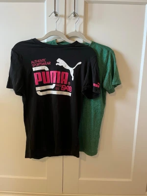 Bundle med två T-shirts  - Bundle med två t-shirts, en svart Puma tröja med vit/rosa tryck och en grön tröja från Petrol Indurstries. Båda är i storlek 164. Puma T-shirten har ett litet hål i höger armhåla som syns på bild nummer 3. Annars är skicket väldigt bra och de är knappt använda. Skriv till mig om ni har frågor.