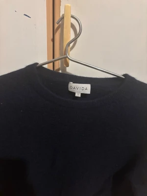 Mörkblå kashmir tröja från Davida - Mysig mörkblå stickad tröja från Davida med rund halsringning och långa ärmar. Perfekt för kyliga dagar och enkel att matcha med olika outfits. Klassisk och stilren design som passar till det mesta.