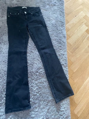 Svarta bootcut jeans - Snygga svarta jeans med bootcut passform och klassisk femficksdesign. Jeansen har normal midja och stängs med dragkedja och knapp. Perfekta till en avslappnad look och passar till det mesta i garderoben.