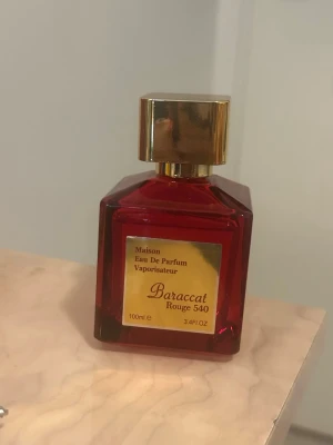 Baraccat Rouge 540 Eau De Parfum - En lyxig parfymflaska i rött glas med guldfärgat lock och etikett. Doften heter Baraccat Rouge 540 och är i 100 ml. Använd någon gång men 90% av innehållet är kvar. 