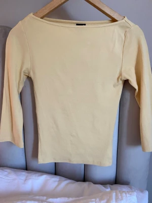 Ljusgul trekvartsärmad topp💓 - En ljusgul topp med trekvartsärm och sitter tajt Toppen har en bred, båtringad hals. Den är ifrån Gina tricot i storlek xs💞💞