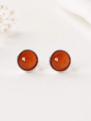 Orangeröda örhängen  - Tjusiga nya örhängen i färgen orangerött.                       Mått: 12mm i diameter                                                        Material: Silverfärgad mässing. Glas                                                                 Örhängena skickas i en hård fin liten kartong där smycket är omsorgsfullt inslaget i vackert silkespapper.