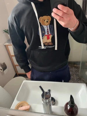 Svart hoodie med björn från Polo Ralph Lauren - Storlek M men passar mer S. Skicket är väldigt bra 