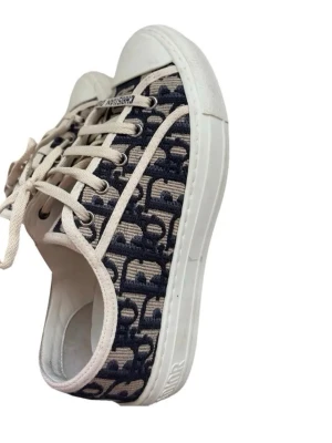 Mönstrade sneakers från Dior - Snygga sneakers från Dior med blått och beige mönster, vita snören och vit sula. Skorna har klassisk låg profil och tydlig Dior-logga på sidan. Perfekta för dig som vill ha något trendigt och exklusivt. De är i storlek 38 och nästan helt nya, använt fåtal gånger, inte min bild . Pris kan diskuteras 