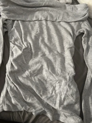 Grå offshoulder topp från Amisu Passar också som S - Säljer en grå offshoulder topp från Amisu i mjukt material. Toppen har lång ärm och en bred kant upptill som ger en snygg offshoulder-look. Perfekt att styla med jeans eller kjol för en trendig vibe.