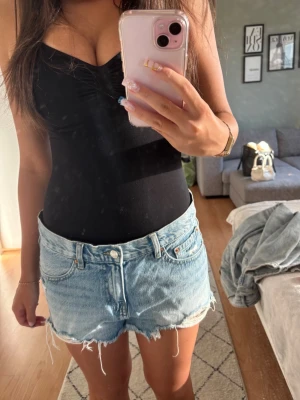 Ljusblå jeansshorts med slitningar - Säljer ett par ljusblå jeansshorts med slitna detaljer.