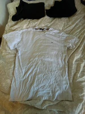 Vit klassisk t-shirt - En enkel vit t-shirt med rund hals och korta ärmar. Liten diskret logga på bröstet. Perfekt basplagg till garderoben och lätt att matcha med allt. Tillverkad i mjuk bomull för skön känsla.