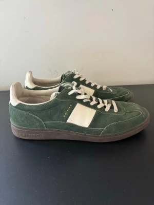 Gröna mockasneakers från Uniform - Säljer ett par gröna sneakers ifrån UNIFIED. Storlek = 43. Endast använda ett fåtal gånger. Hör av dig vid fråga eller fundering!