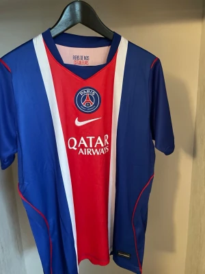 PSG Hemma Fotbollströja 26/27 - Helt ny och trendig PSG 2026 / 2027 säsongs Hemma version fotbollströja. Nypris runt 1099kr. Passformen på tröjan är som en oversized t-shirt i storlek S. Tröjan kommer med original förpackning och skickas i förstärkt påse för att hindra skador eller slit under frakt. Kontakta vid funderingar, och kolla min profil om du vill se andra tröjor. 