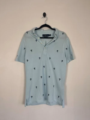 Ralph Lauren Knit Oxford Pikétröja Ljusblå Mörkblå Broderat Mönster Stl S 100% Bomull - Ralph Lauren Knit Oxford Pikétröja Ljusblå Mörkblå Broderat Mönster Stl S 100% Bomull  • Storlek: S • Färg: Ljusblå • Passform: Classic Fit • Krage: Button-down-krage • Material: 100% bomull  Skick: Plagget är i väldigt fint skick. Eventuella anmärkningar anges alltid tydligt i beskrivningen och visas på bilderna.  Nypris: Cirka 2 000 kr.  📦 Skickas snabbt och packas omsorgsfullt. 💬 Hör gärna av dig om du har frågor eller vill se fler bilder. 🤝 Samfrakt erbjuds vid köp av flera plagg – kika gärn