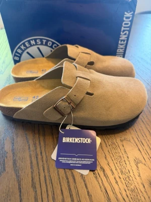 Beige mockatofflor från Birkenstock - Säljer ett par Birkenstock Boston i nyskick. Storlek: EU 42 Färg: Taupe ✔️ Noggrant kontrollerade innan försäljning ✔️ Fler bilder kan skickas vid önskemål ✔️ Snabb och säker frakt (Boxen ingår ☑️) 📩 Har du frågor är det bara att skicka ett meddelande – vi svarar snabbt. Tack för att du tittar på annonsen!