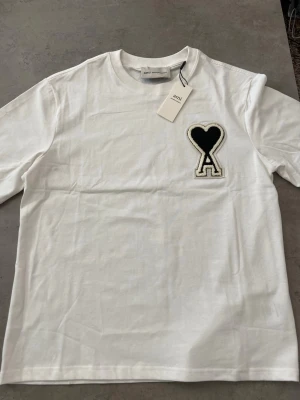 Ny ami Paris t shirt vit i storlek M - Hej Säljer en vit AMI Paris t-shirt i nyskick, endast provad. Normal passform i storlek M. Säljes i befintligt skick enligt bilderna.  Skickas samma dag!