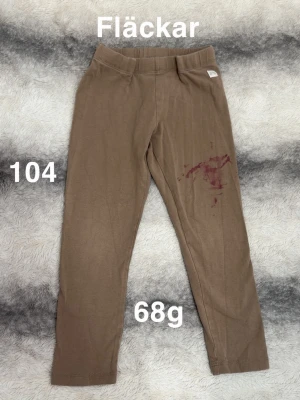 Bruna leggings - Snygga bruna leggings med resår i midjan. De har en enkel och klassisk design utan synliga fickor eller detaljer. Perfekta för en avslappnad och bekväm stil.🌸 Fläckar. Storlek 104
